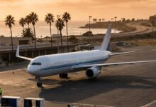 Commercial aircraft at regional airport terminal with coastal scenery